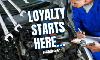 mechanic filling out clipboard while inspecting under hood of vehicle