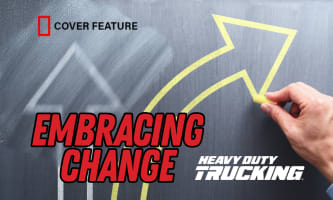 Illustration of a chalkboard with a hand drawing an arrow curving away from a partially erased straight arrow with the words "Embracing Change," the Heavy Duty Trucking Logo and the "cover feature" graphic.