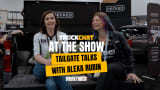 Alex Rubin and Lauren Fletcher smile on a tailgate in the DECKED booth, Truck Chat at the Show Tailgate Talks