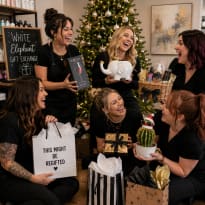 Salon team members laughing at a White Elephant gift exchange