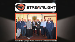 Image of a group of men in business attire receiving an award set against a black background and a Streamlight logo up top.