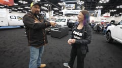 Juan Ibarra and Lauren Fletcher share a laugh during a Work Truck Week conversation surrounded by work trucks and exhibit booths