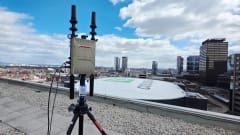 Rooftop view off a drone detection devise with two small rubber antennas with an view overlooking a large domed event venue.