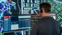 Man working in front of multiple computer screens.