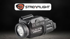 Product image of a Streamlight TLR-7 X tactical flashlight on a dark background. The compact black weapon-mounted light is shown in close-up beneath the Streamlight logo, highlighting its lens, controls, and mounting hardware.