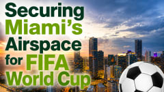 Graphic promoting airspace security for the FIFA World Cup, featuring the Miami skyline at sunset with large text reading “Securing Miami’s Airspace for FIFA World Cup” and a soccer ball in the foreground.
