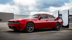 red battery-electric vehicle using a Tesla Supercharging station