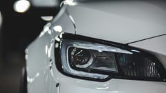 Closeup of white car's headlight, front end