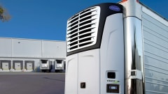 Carrier Transicold electric transport refrigeration unit on stationary trailer with loading docks in the background