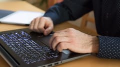 Photo of suited man's hands over a computer keyboard