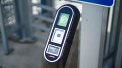 An image of a ticket validator in front of a security gate.
