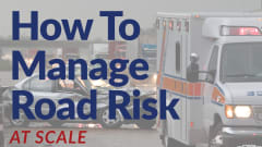 Ambulance and damaged car at a crash scene on a rainy roadway, illustrating workplace transportation risks and the growing focus on road safety management for fleets.