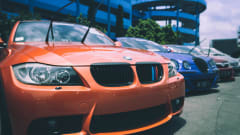 Orange BMW with windshield wipers sticking up.