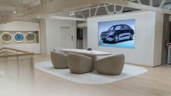 White meeting room in car dealership with rims displayed on wall and projected screen