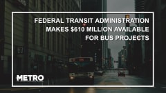 A public transit bus at a pedestrian crosswalk with text reading "Federal Transit Administration Makes $610 Million Available for Bus Projects."