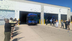 A group of people with confetti cannons and a Pace transit bus.
