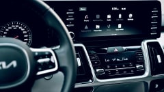 Phot of a dark Kia vehicle interior with steering part of steering wheel and dashboard