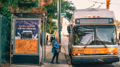 An MBTA bus with a passenger boarding at shelter. 