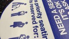 An up close image of WMATA priority seating sticker reminders.