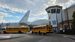 Two school buses parked in front of the Wings Over the Rockies Air & Space Museum in Denver.
