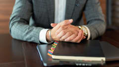 Photo of businessman's hands resting on files on a desk