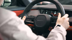 inside of car, person with hands on black steering wheel