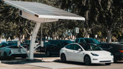 white electric car charging at an outside port