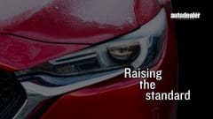 red Mazda headlight/bumper, Raising the standard, Auto Dealer Today logo in white