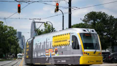 The CATS Gold Line in service with the city skyline in the background.