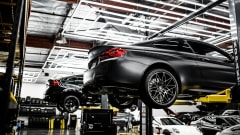 Photo of several cars on lifts in a service center