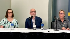 Three people at a table for a panel discussion