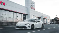 Photo of white Toyota car in front of dealership
