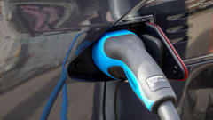 EV charger inserted into dark-colored car port