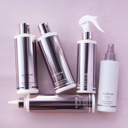 a collection of hair products in shiny pink bottles