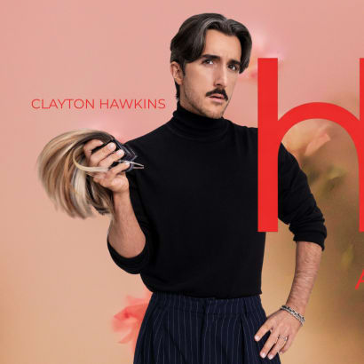 A man in a black turtleneck, holding hair extensions.