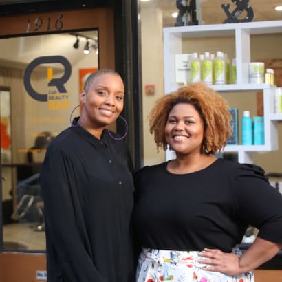 Owners Chenica Racine and Ricka O'Bannon outside the branded front door of their salon C&R Beauty Bar.