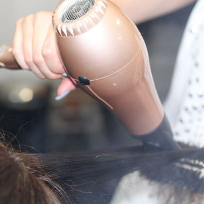 A stylist using a blowdryer