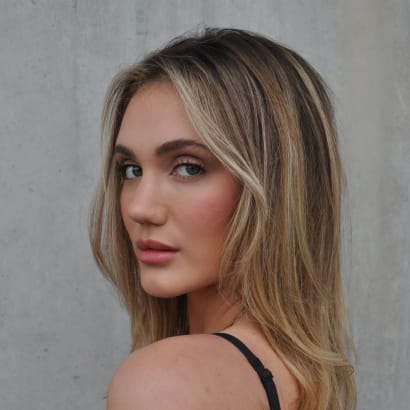 Young woman with medium-length, silky hair featuring multidimensional highlights and shine.