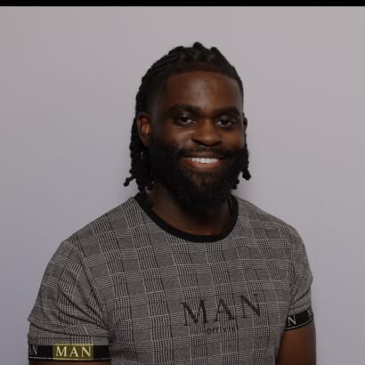 A man with dark hair and a beard, smiling.