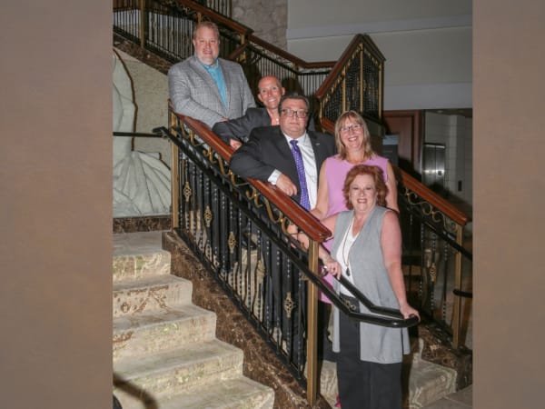 Honorees gather for a photo on the hotel lobby steps. 