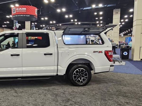 A white four-door pickup truck with upfit