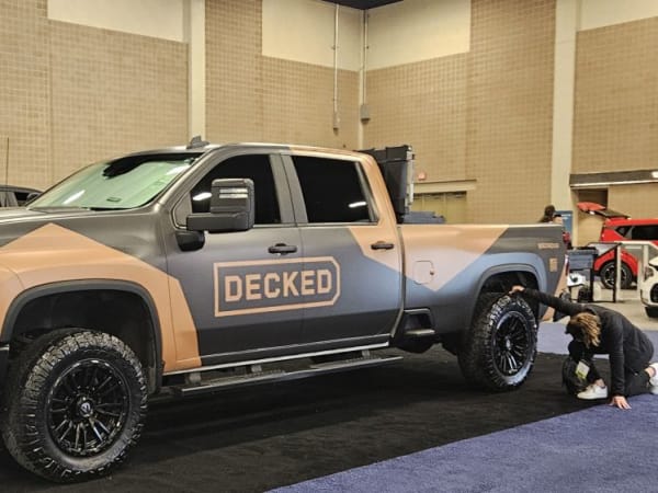 A brown and black pickup truck with DECKED logo