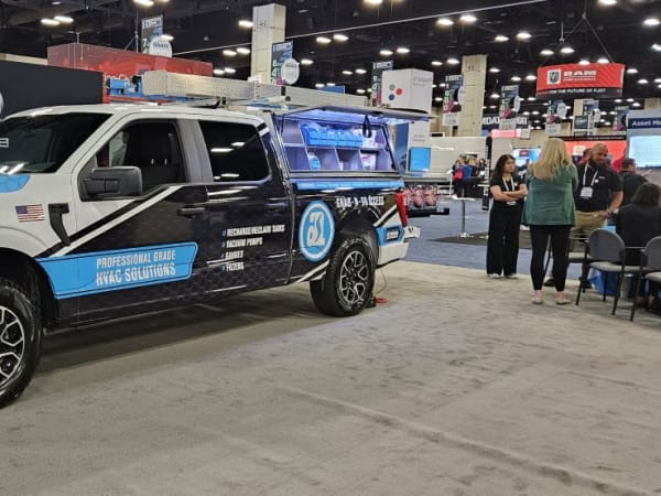 A white, blue, and black pickup truck with Adrian Steel badging and grab-and-go storage
