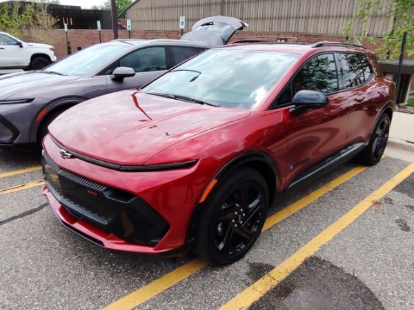 Two small SUVs, one red and one gray, parked in a lot.
