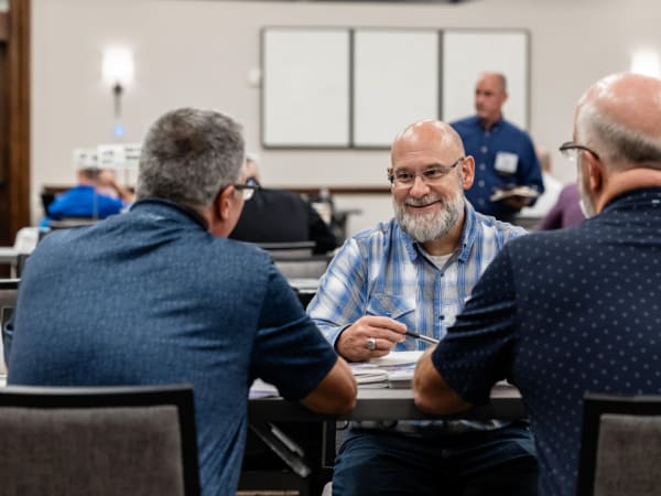 Attendees leaning in and exchanging ideas during a one-on-one Work Truck Exchange meeting.