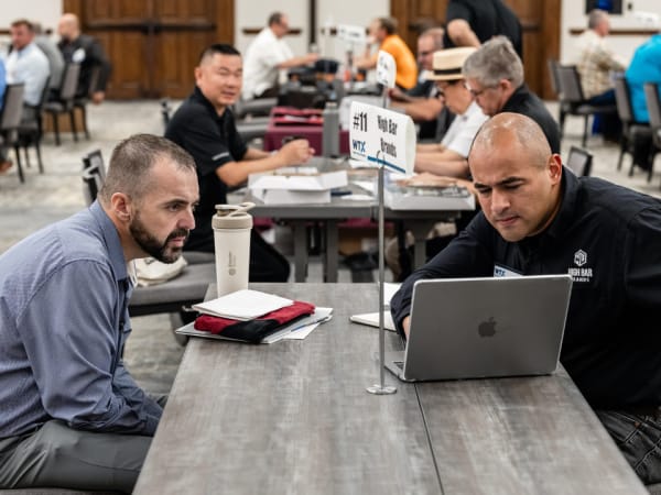 Two attendees reviewing details on a laptop during a focused Work Truck Exchange session.