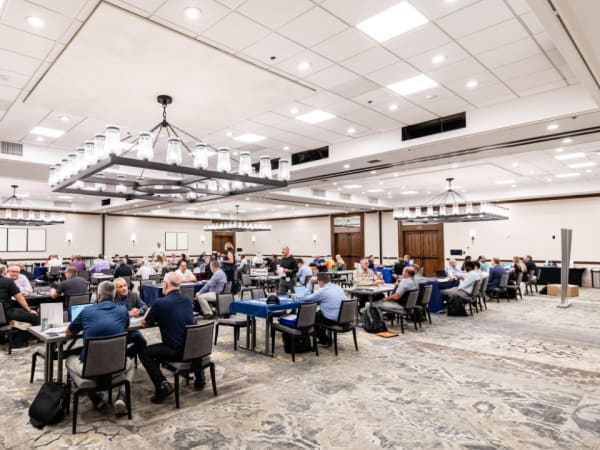 Wide view of Work Truck Exchange with dozens of attendees engaged in meetings.