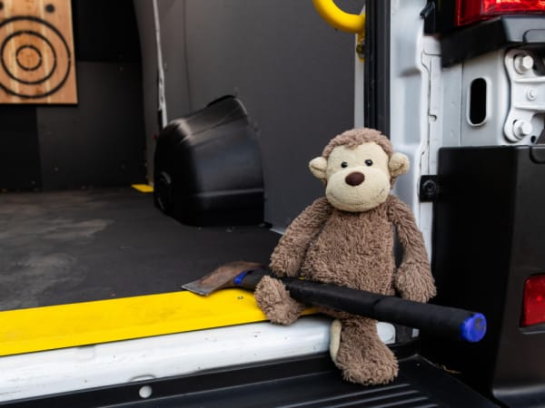 Stuffed monkey sitting with an axe inside the Legend Fleet axe-throwing van at Work Truck Exchange 2025.