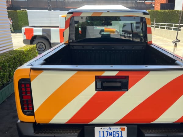 A rear view of the pickup truck including the flat bed and the cab.