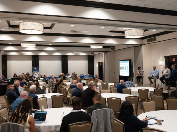 Wide shot of hotel conference room during a presentation. 